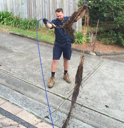 One of our plumbers unblocking a blocked sewer pipe