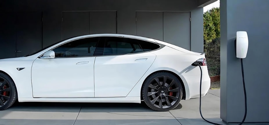 White Tesla electric vehicle being charged at home