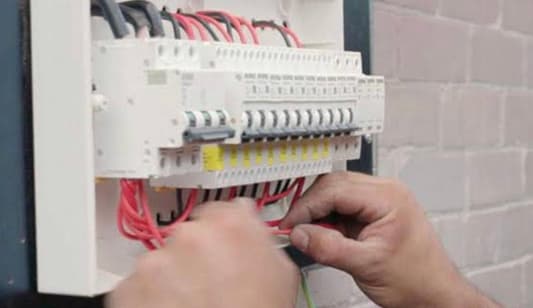 An electrician testing a switchboard