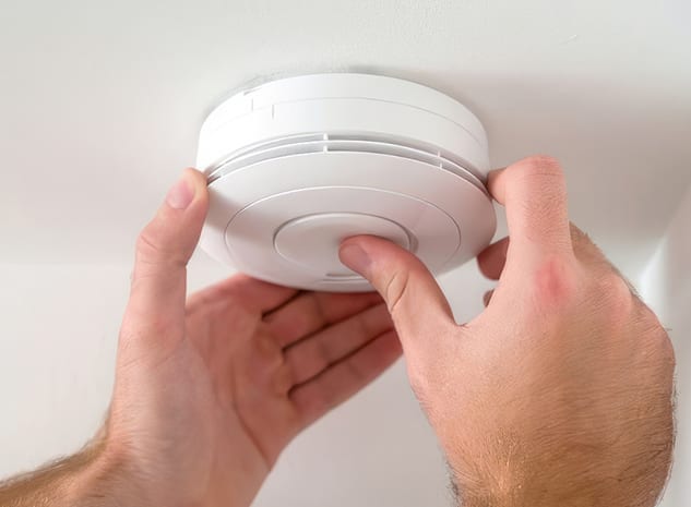 A smoke alarm being tested by an electrician