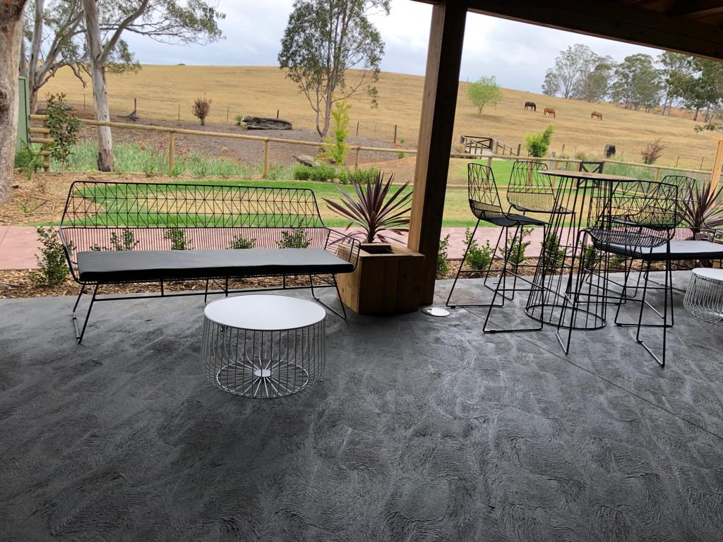 A patio with a table and chairs suitable for Black Arrow 3 Seater Lounge Hire, offering a stunning view of a field.