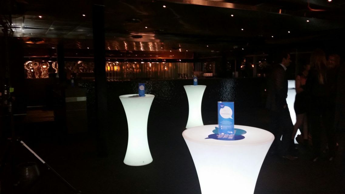 Glow cocktail bar tables hire in a dark room.