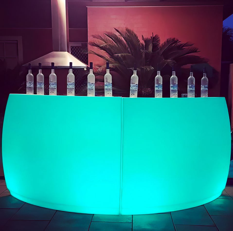 A curved green LED bar with glowing bottles on top.