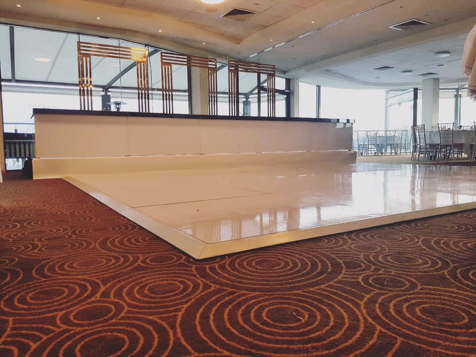 A glossy white dance floor in a large room, perfect for bridal events or table hire purposes.