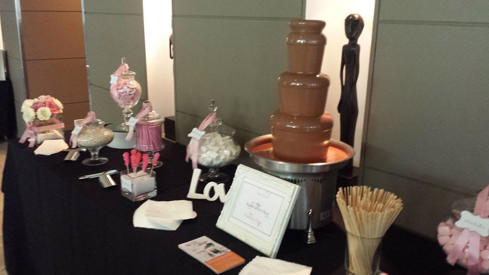 Package 2 - A table with a medium commercial chocolate fountain and candy on it.