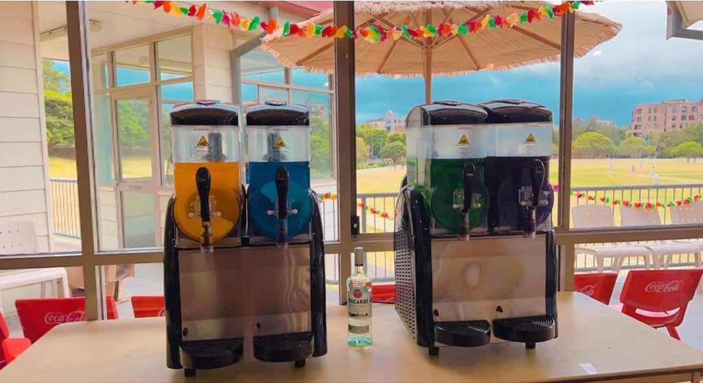 Two Slushie Machine drinks are sitting on a table in front of a window, offering a refreshing selection of 240 drinks.