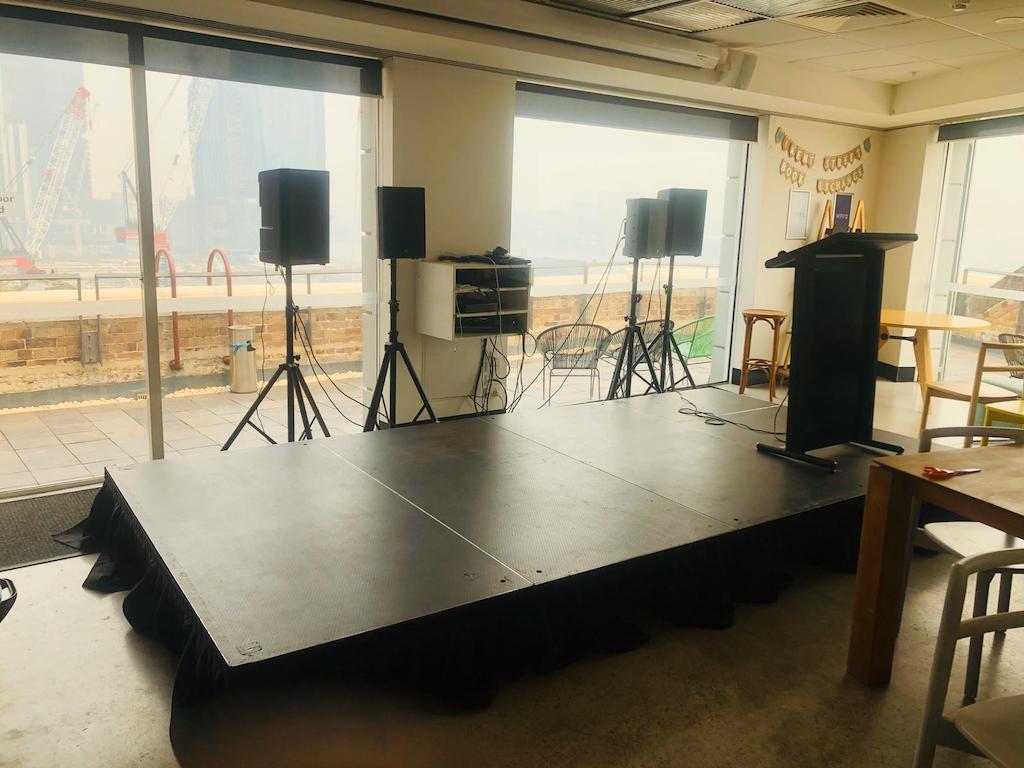 A room set up with speaker stands for hire, overlooking the city.