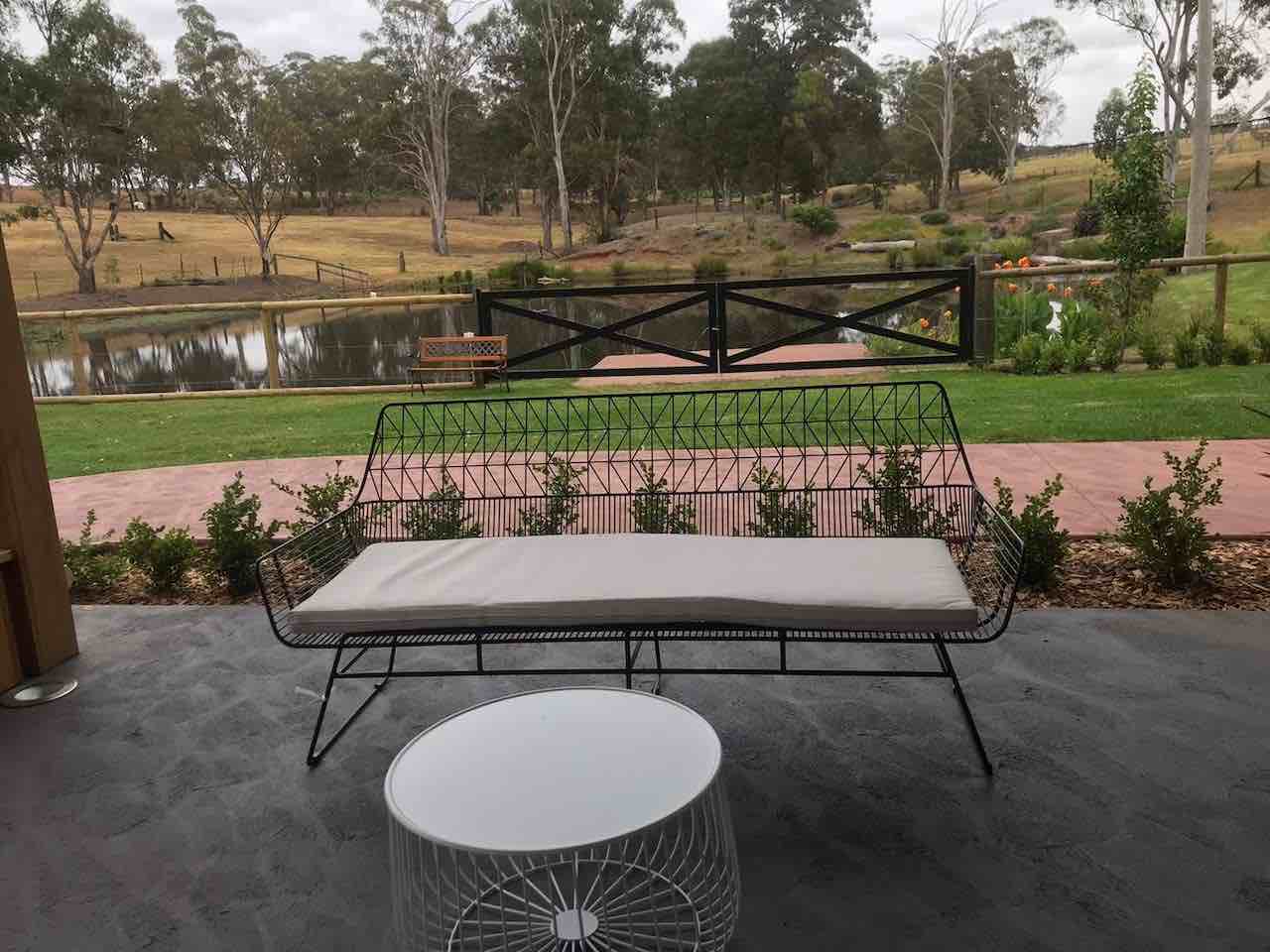 A table on a patio with a view of a pond.