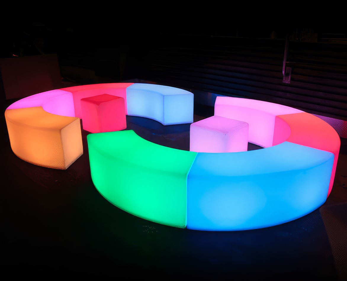 A set of colorful Glow Benches in a dark room.