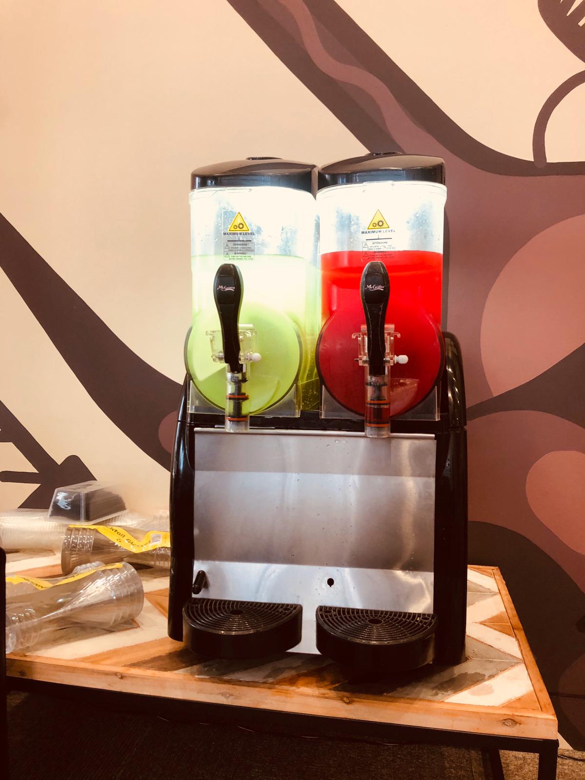 Two drinks are sitting on top of a table, prepared from Slushie Machine Hire: Pkg 4 with a total of approximately 180 drinks served.