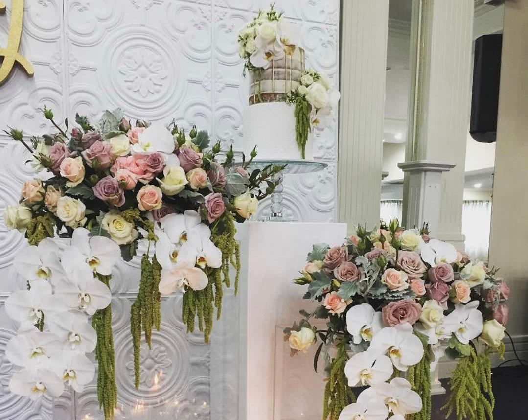 A large white square plinth hire, adorned with flowers and orchids