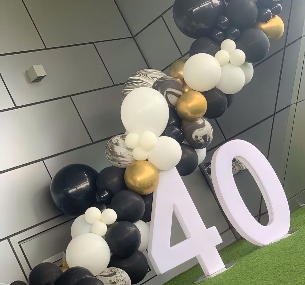 A black and gold balloon arch with the number 40 for a Glow Numbers Hire event.