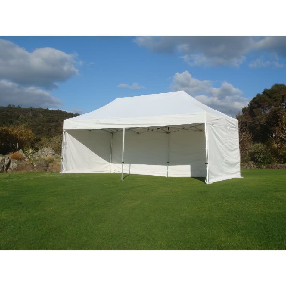 A 3mx6m white pop up tent on a grassy field.