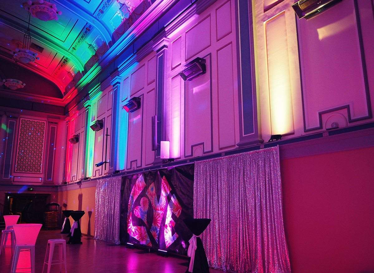 A vibrant and spacious hall illuminated with dazzling Par Can lights, setting the dance floor aglow.