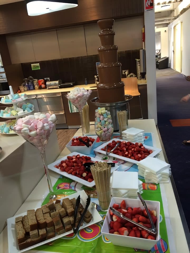 A chocolate bar with strawberries and other desserts on a table, showcasing the abundance of Strawberries 1kg.