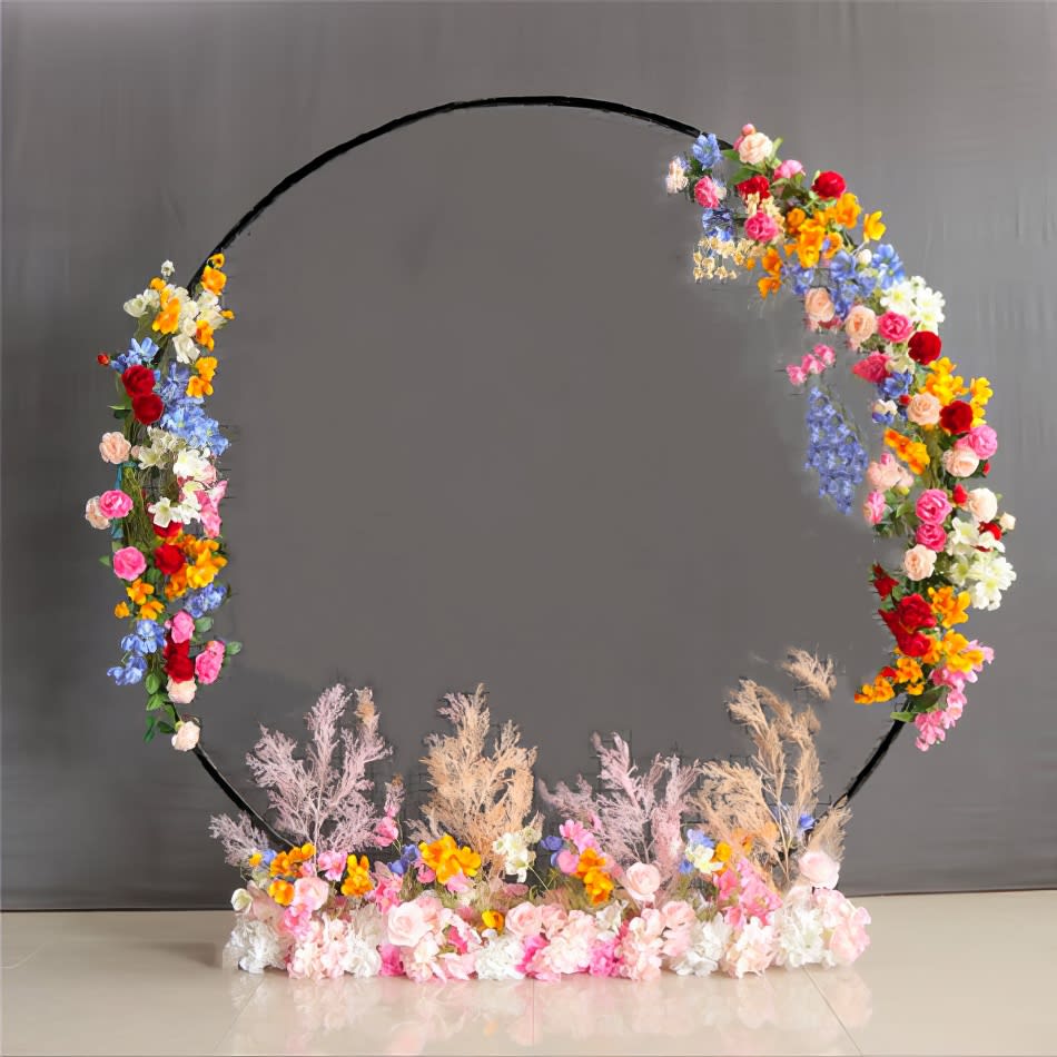 A flower wreath made of flowers on a table with a black hoop backdrop.