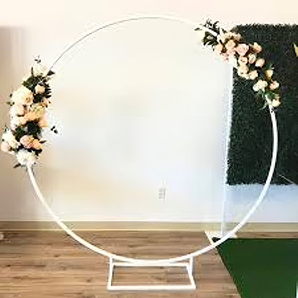 A white wedding arch adorned with flowers on it.