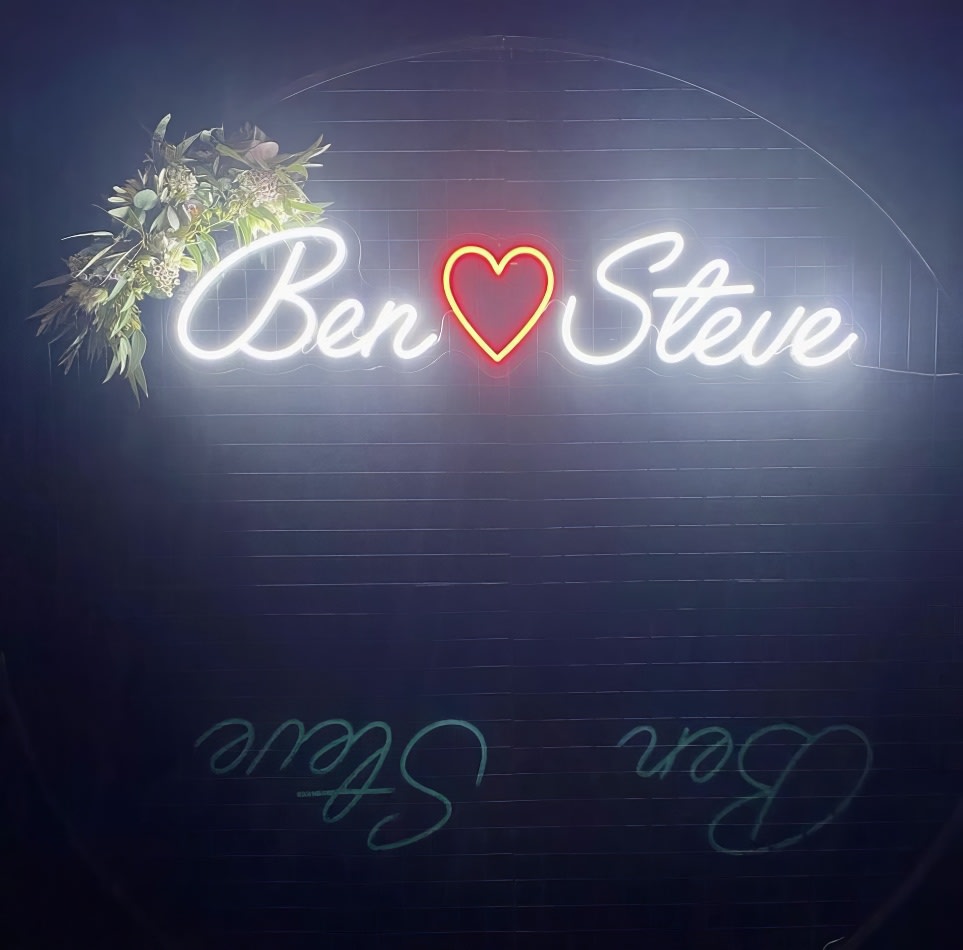 A neon sign with the word ben steve on it, set against a circular black backdrop hire.