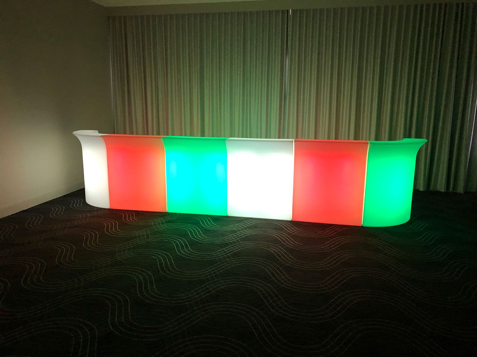 A vibrant LED bar, glowing with red, green, and blue hues, illuminating the room.