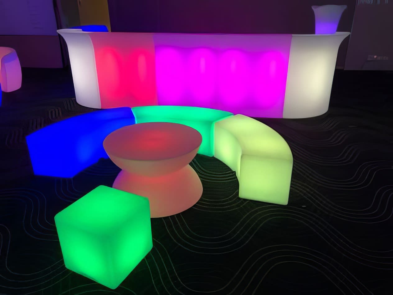 A large, colorful coffee table and chairs glow in the room.