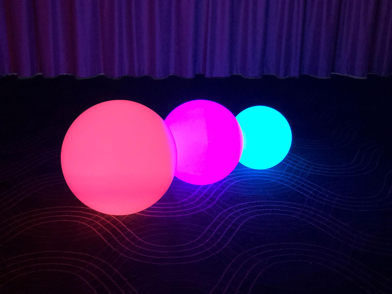 Three vibrant led balls on a carpet.