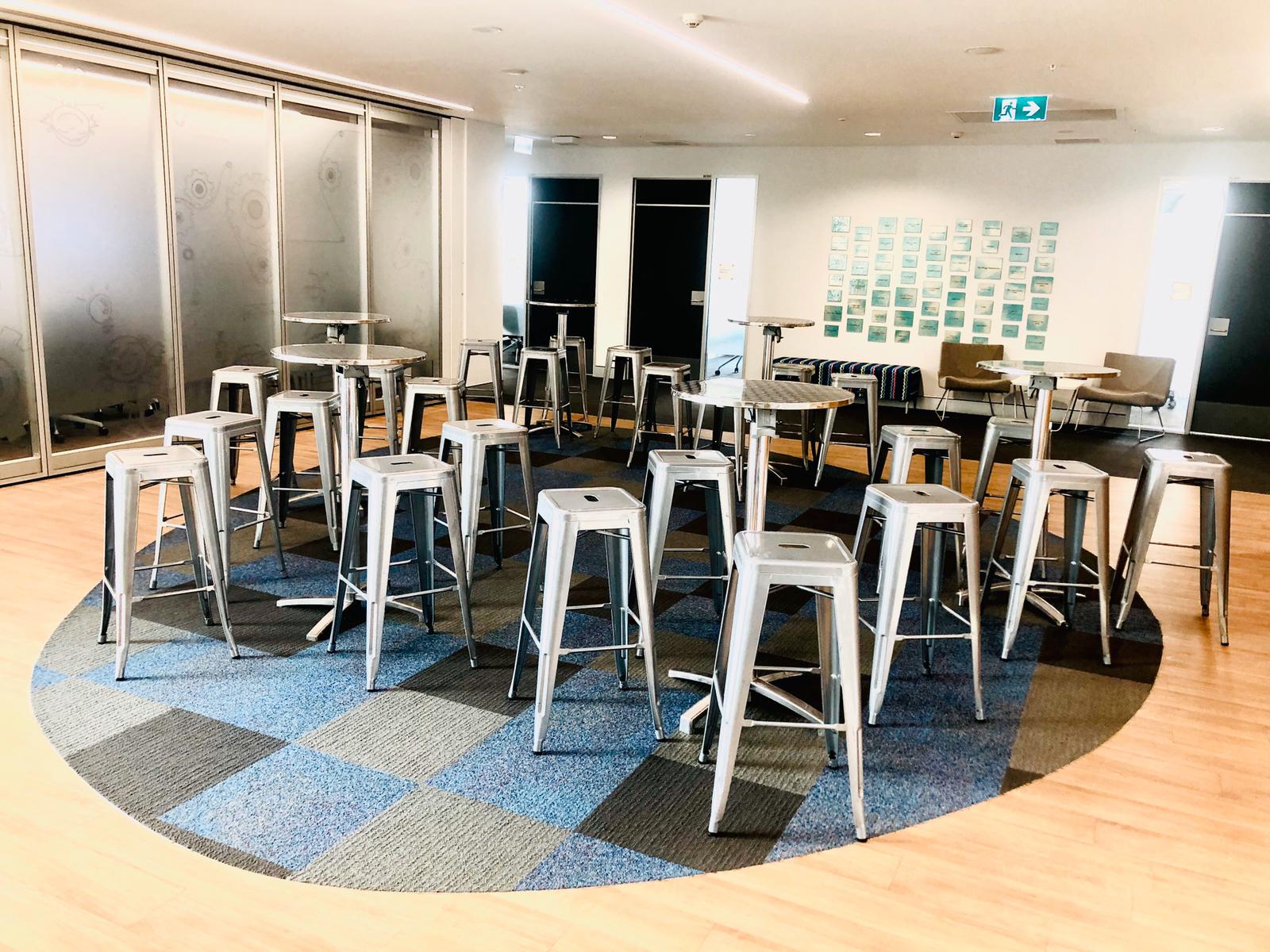 A group of Silver Tolix stools in a circular room.