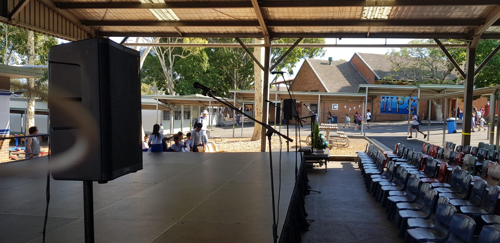 A stage set up in a school auditorium with Speaker Stands.