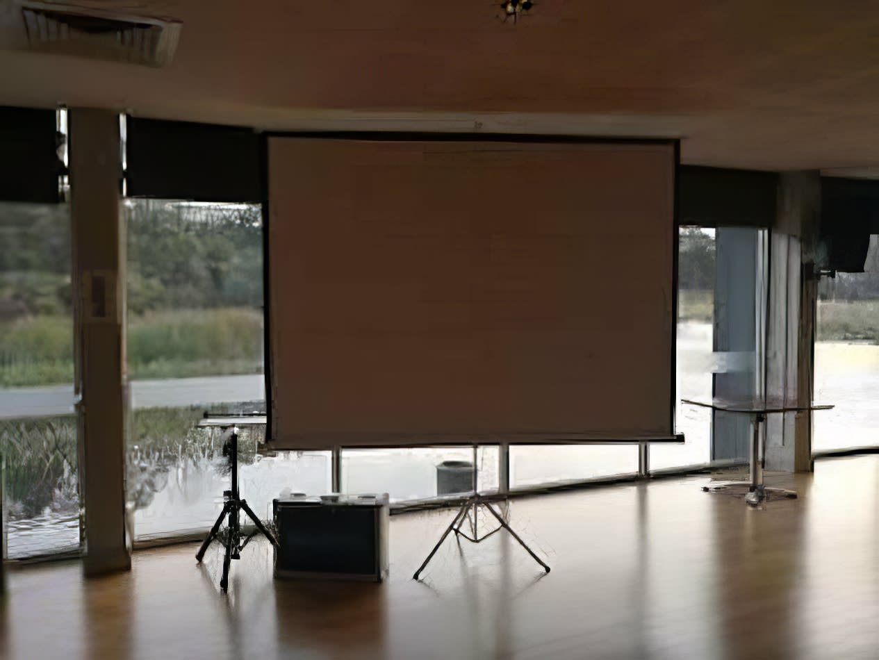 A spacious room featuring a projector screen on one side.