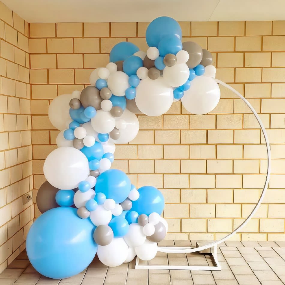 A balloon arch decorated with blue and white balloons, perfect for a white hoop backdrop hire.