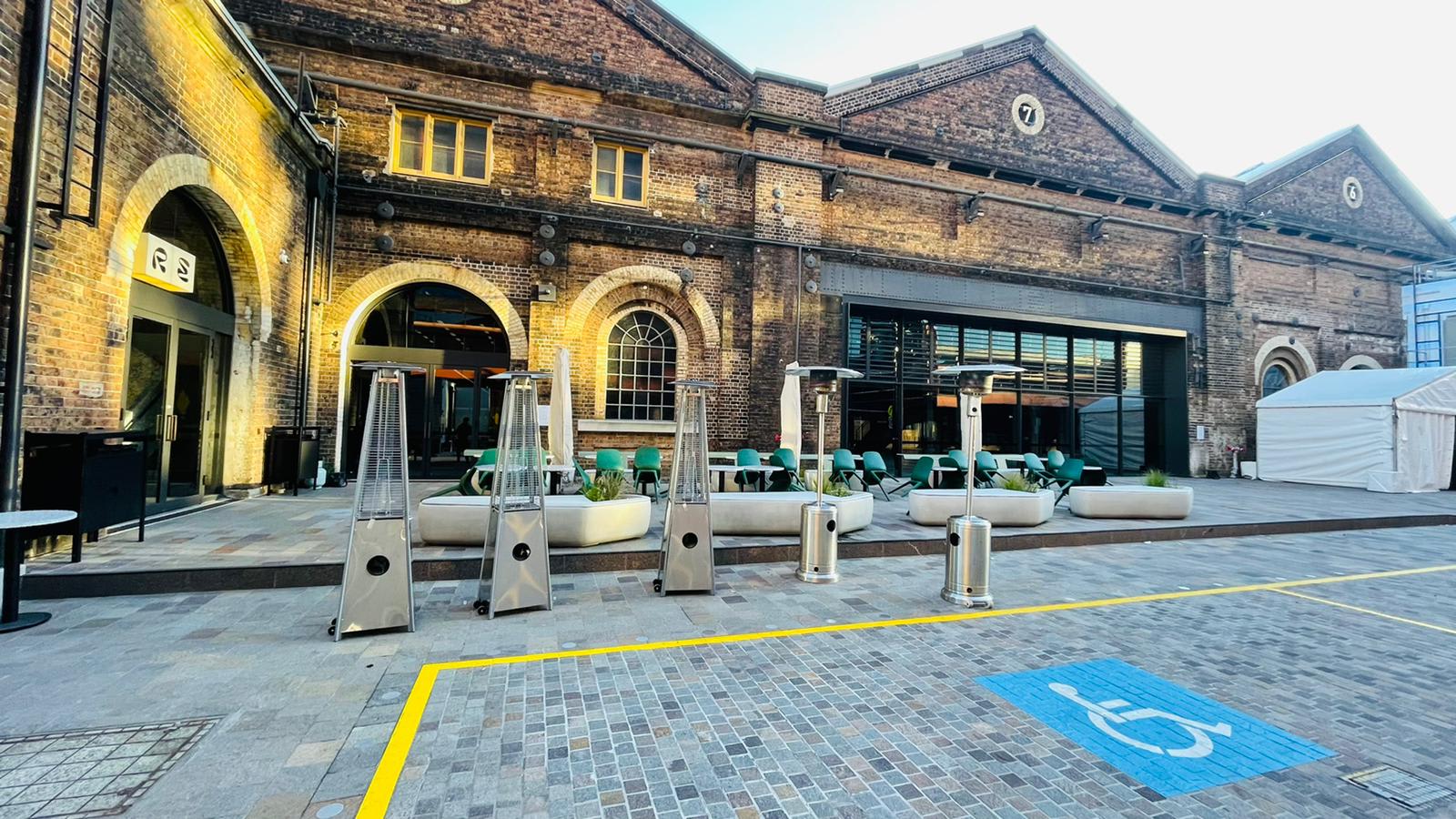 A brick building entrance with a wheelchair ramp available for hire.