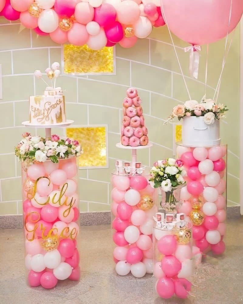 A pink and white birthday party with Clear Acrylic Round Plinth Hire for balloons.