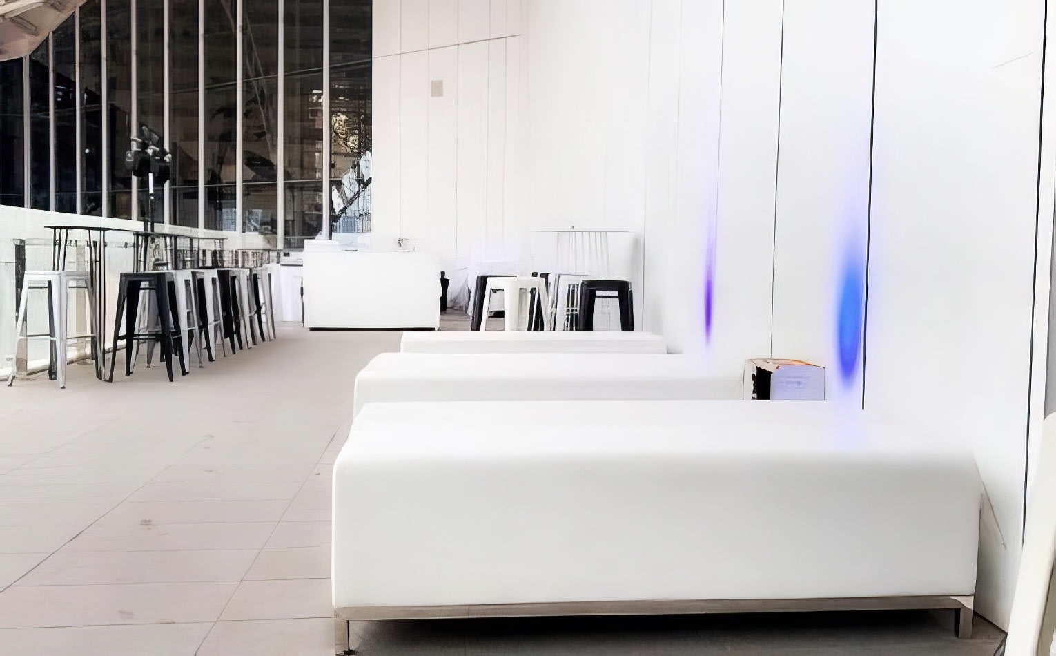 White couches and chairs, including a white ottoman bench, in a large room.