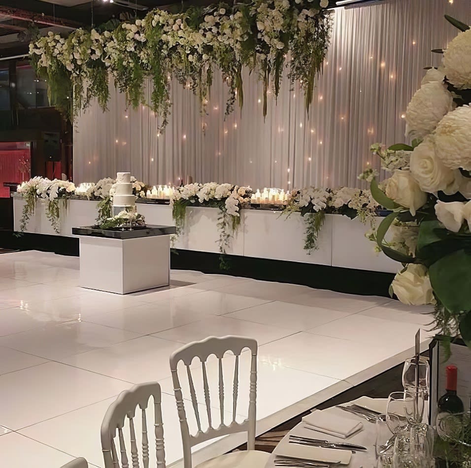 A beautiful white wedding reception set up adorned with elegant white flowers.