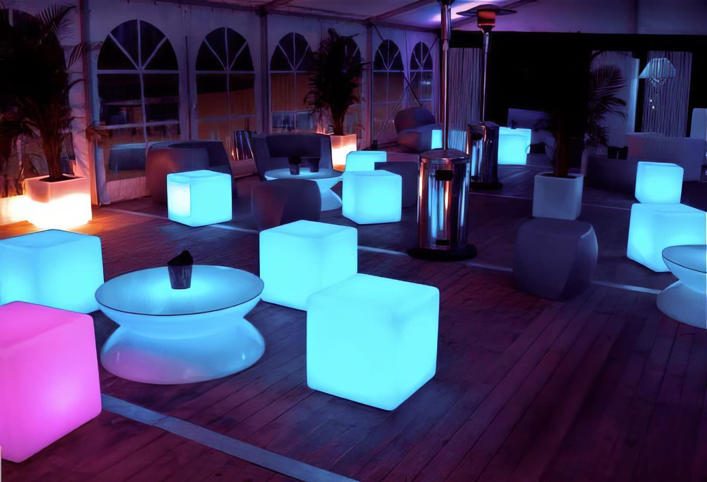 A group of colorful LED glow cubes on a wooden deck for hire.