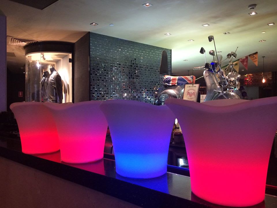 A group of lighted stools in a bar, creating a glowing ambiance.