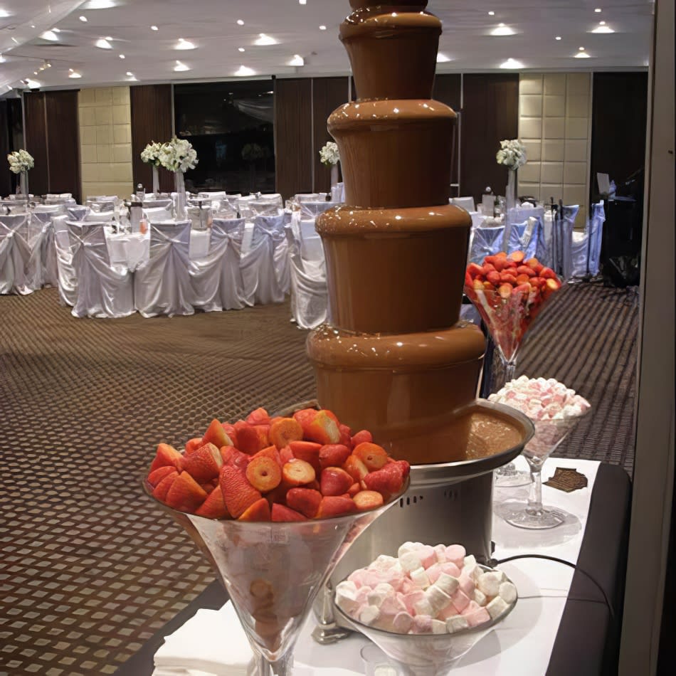 A Package 6 King chocolate fountain overflowing with strawberries and marshmallows.