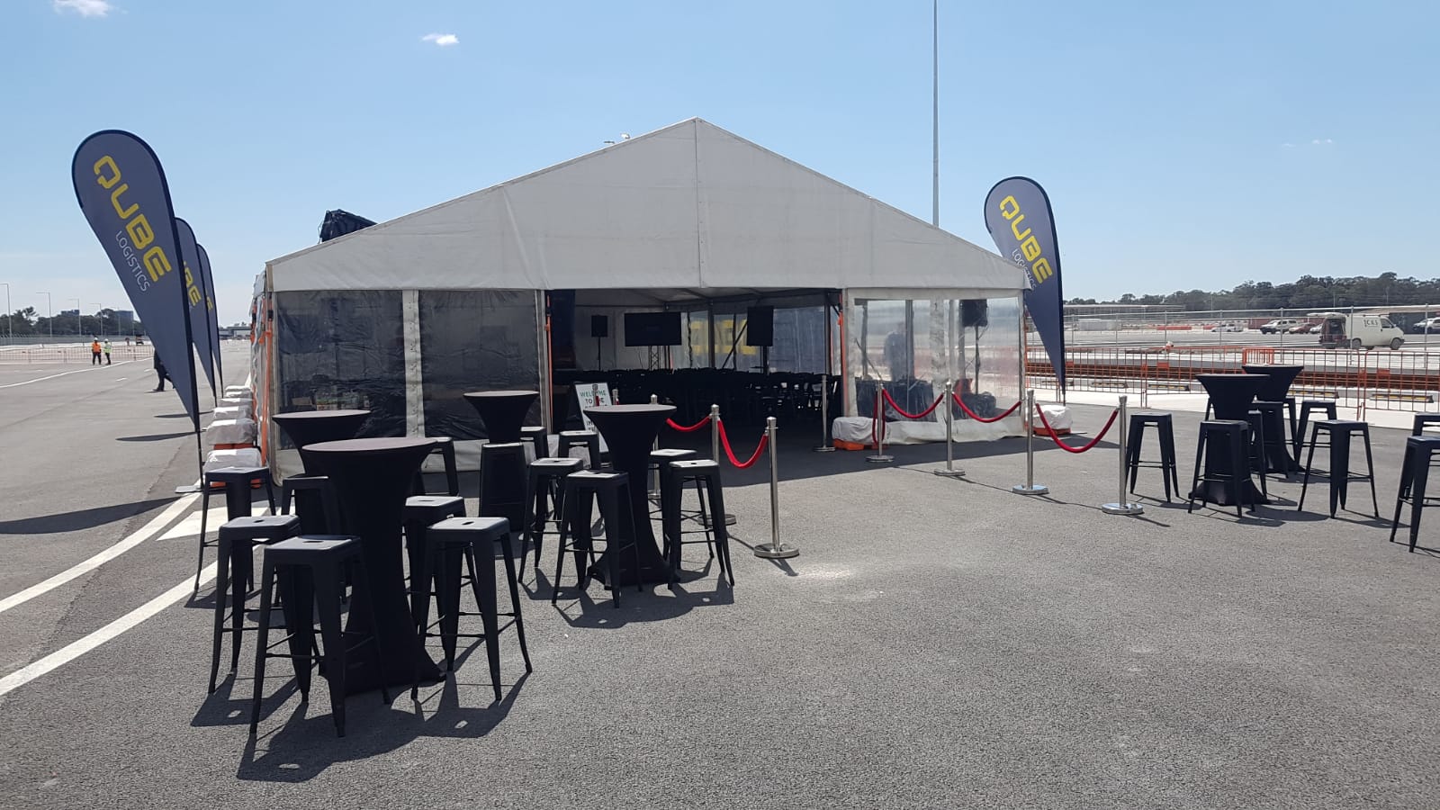 A spacious framed marquee, measuring 8m x 21m, set up with tables and chairs.