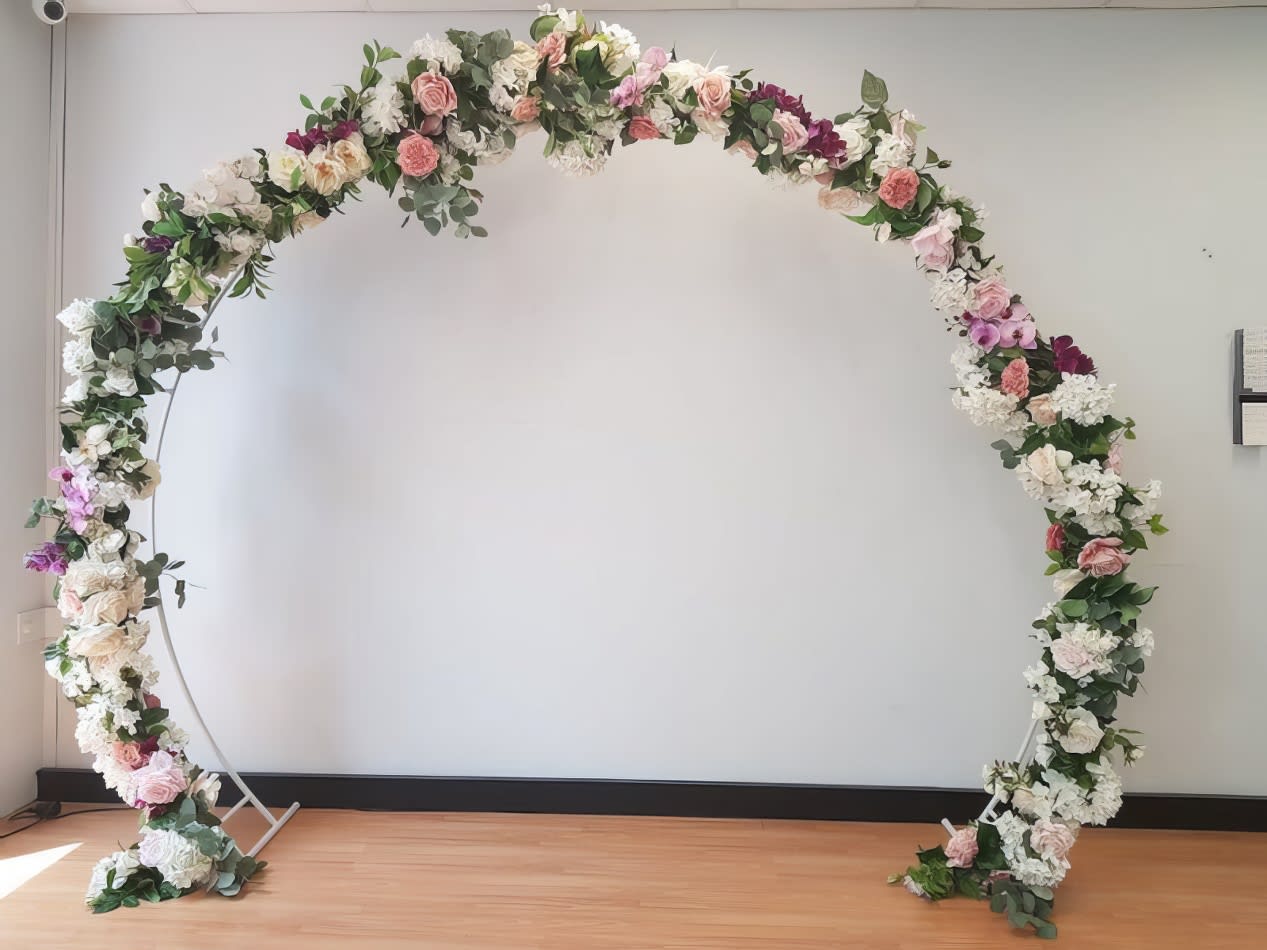 Bridal Arch Hire adorned with white and pink flowers.