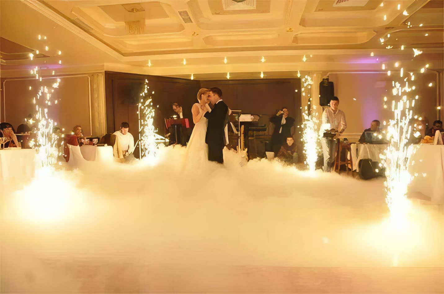 A bride and groom dancing with sparklers in the air, enhanced by the presence of a skilled operator offering dry sparkler hire.