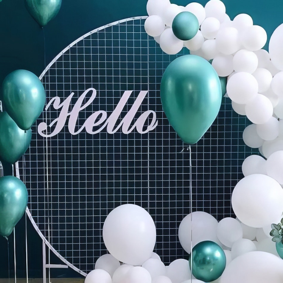 A white and green balloon arch with the word hello displayed on a circular mesh backdrop.