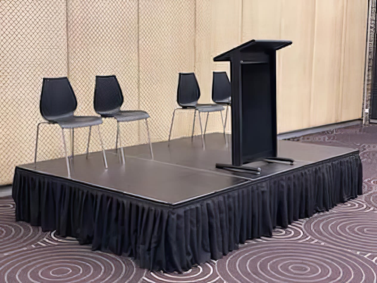 A podium with four chairs available for Lectern Hire.