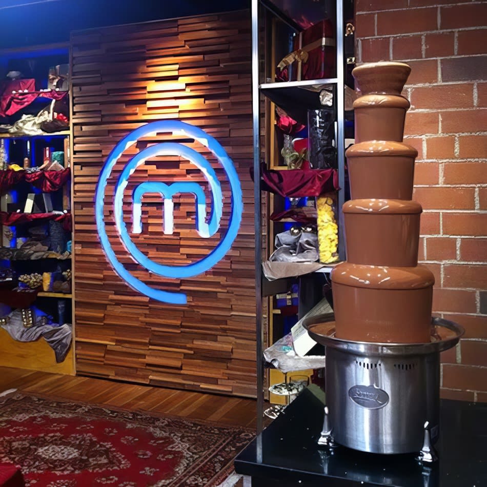 Package 4 - A large commercial chocolate fountain displayed in front of a sign that says masterchef.