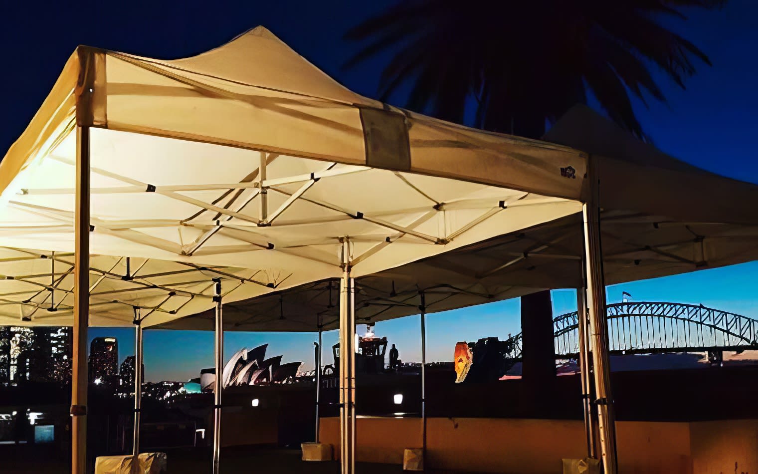 Sydney harbour bridge and sydney opera house at dusk covered by a 4mx8m Pop Up Marquee with a White Roof.