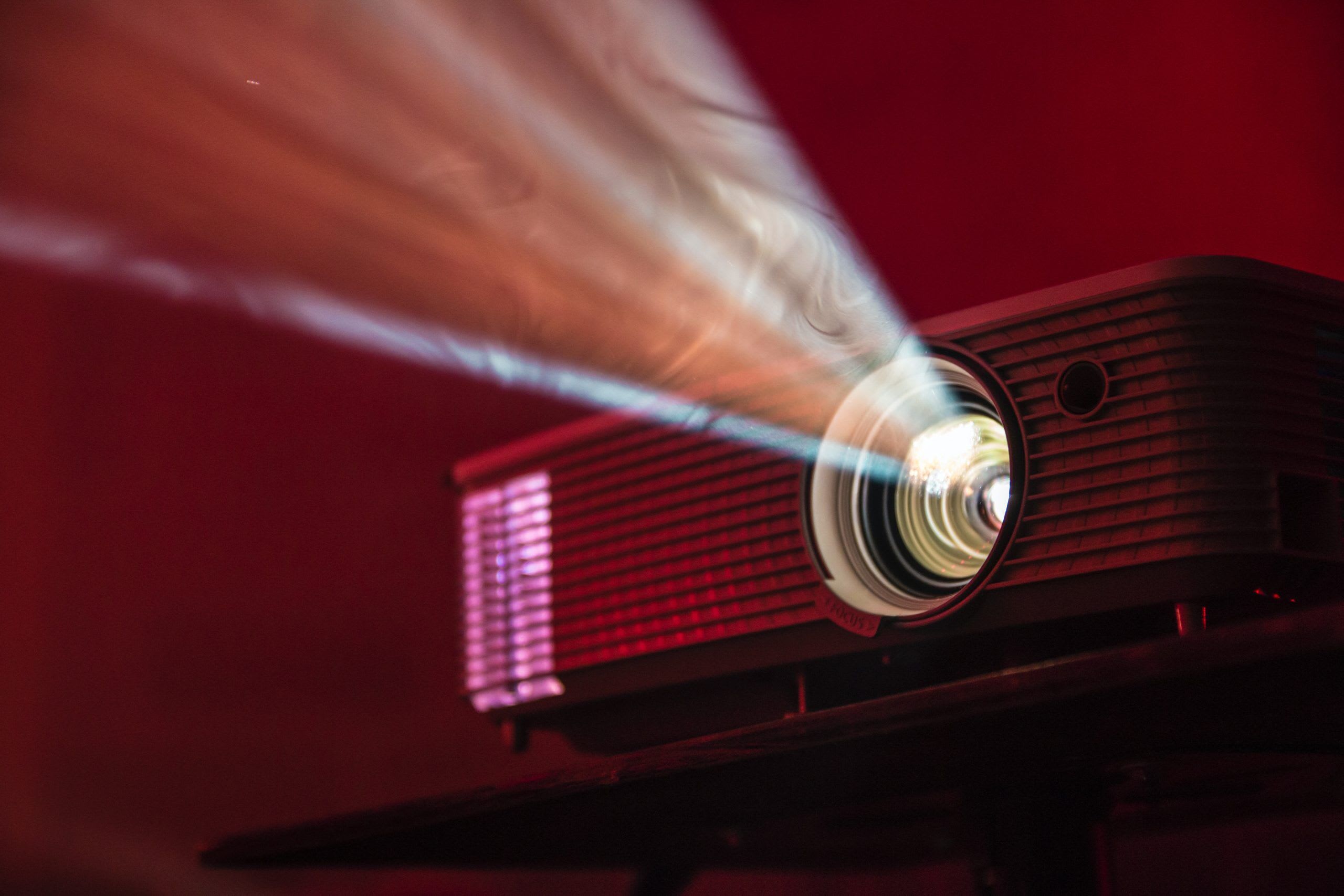 A 2500 Lumens digital projector with a red light shining on it available for hire.