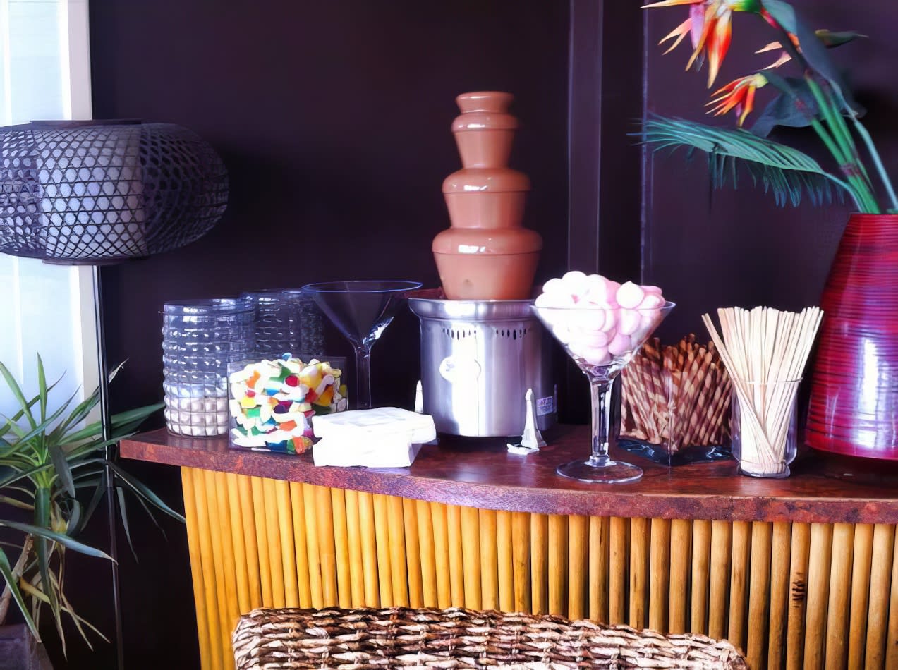 A table with a chocolate fountain, vase of flowers, and wafer biscuits (per 100 biscuits).