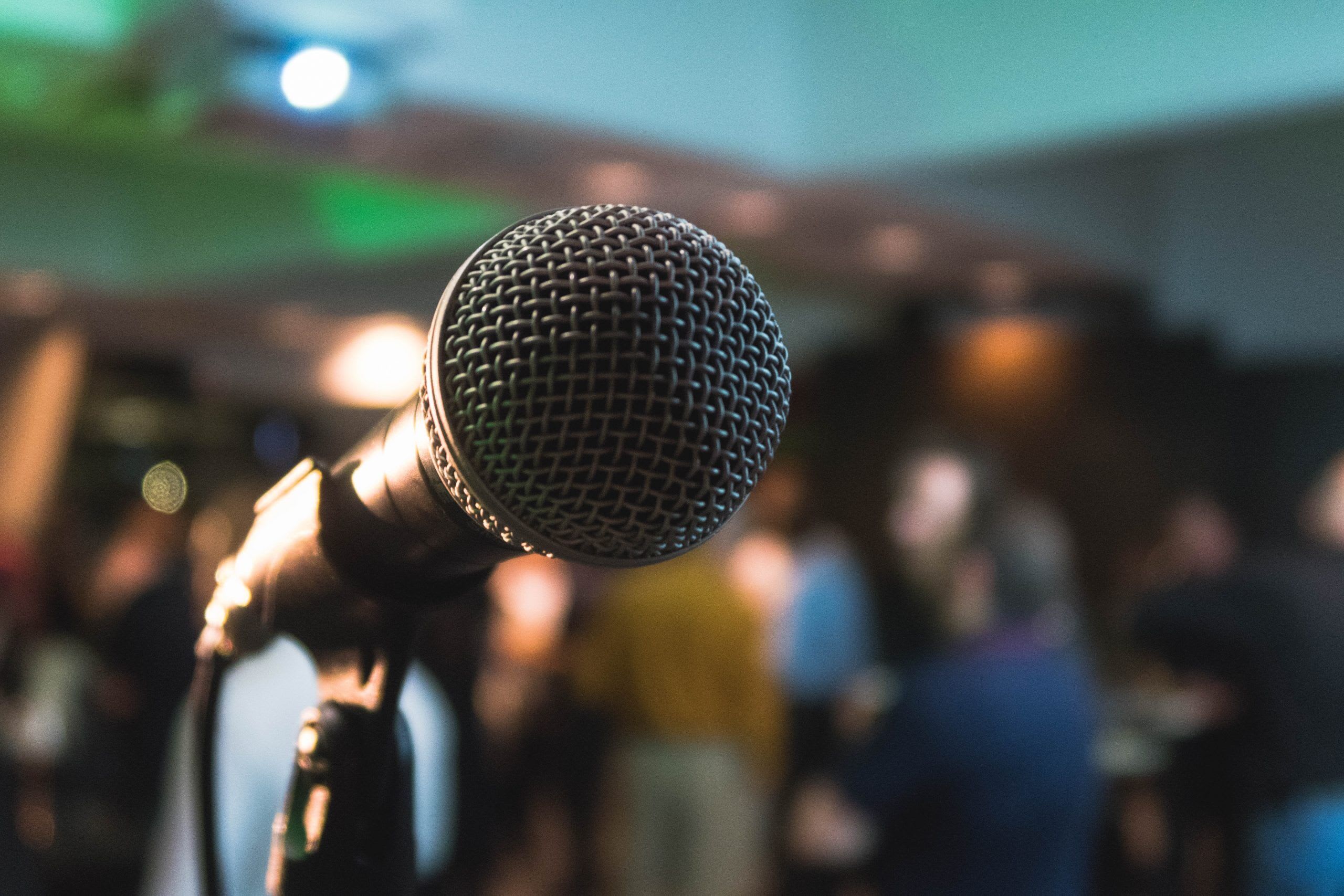 A wireless microphone in front of a crowd of people.