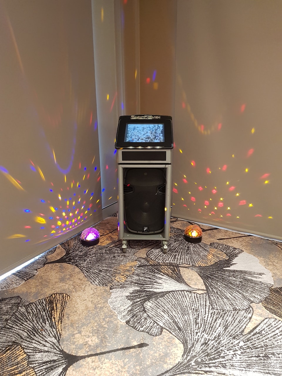 A karaoke machine with colorful lights, available for Jukebox Hire Only in a room.