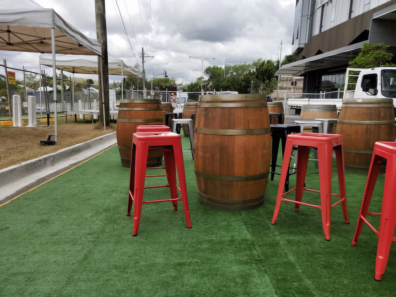 A group of red Tolix stools on a grassy area.