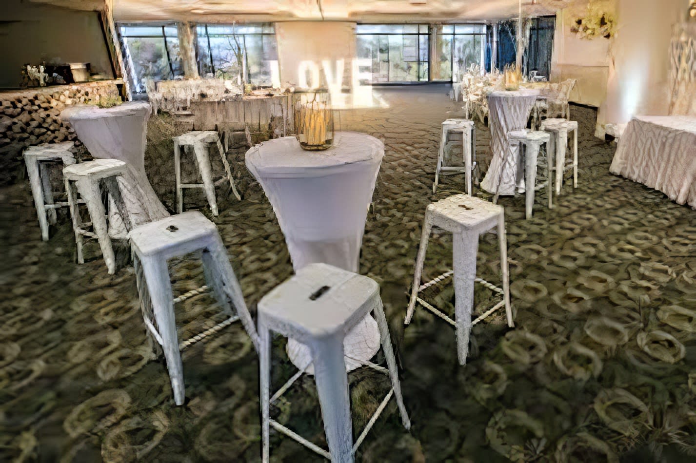 A spacious room furnished with white Tolix stools and tables.