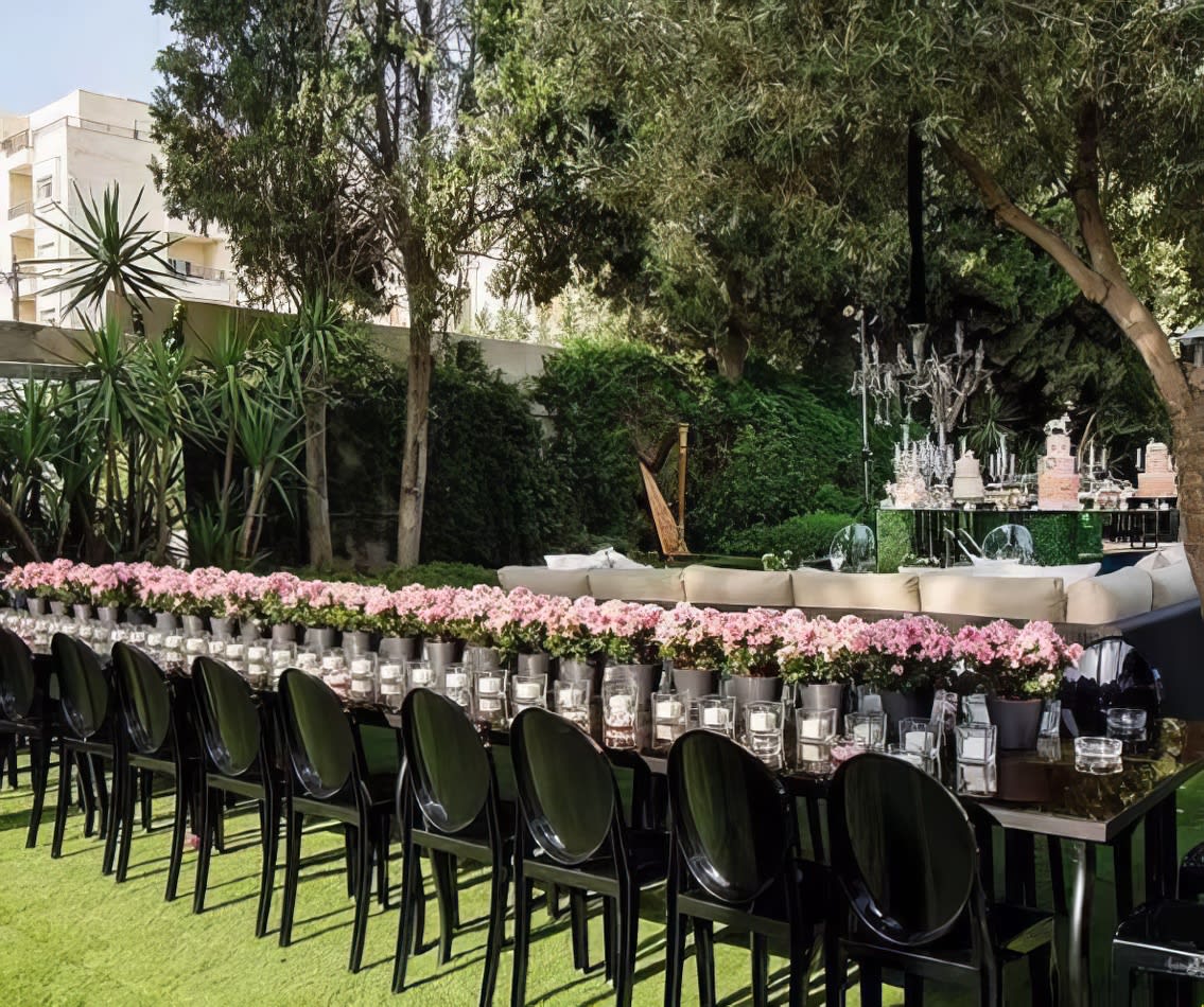 A table adorned with black chairs and pink flowers.